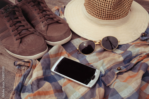 Clothing accessories, blue shirts, hat and sneakers , smartphone