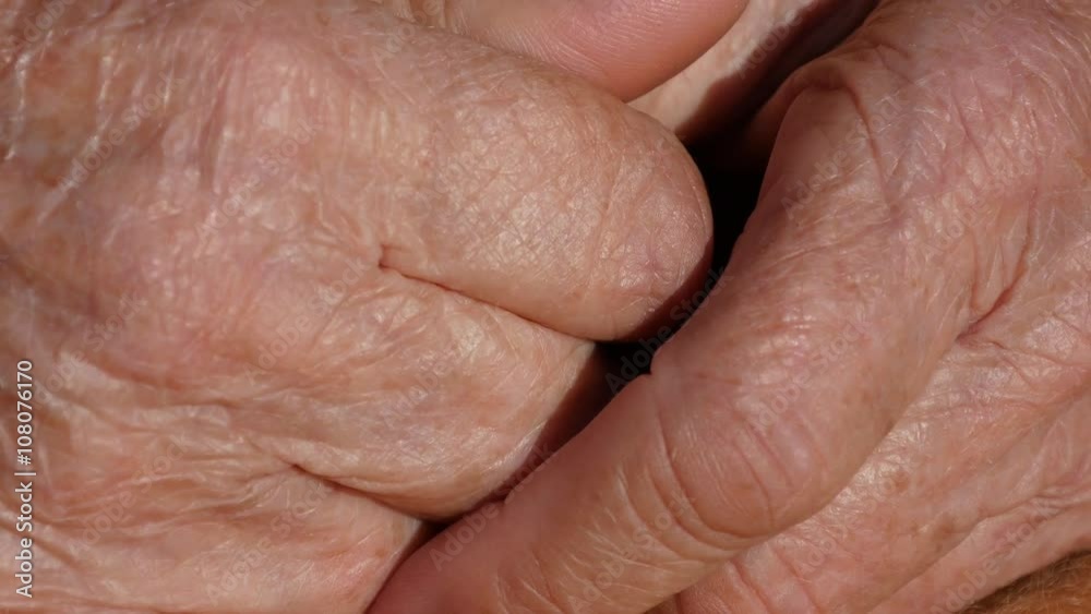 Senior woman massages painful hands . Wrinkled skin on the fingers of grandmother close-up Senior woman massages painful hands . Wrinkled skin on the fingers of grandmother close-up