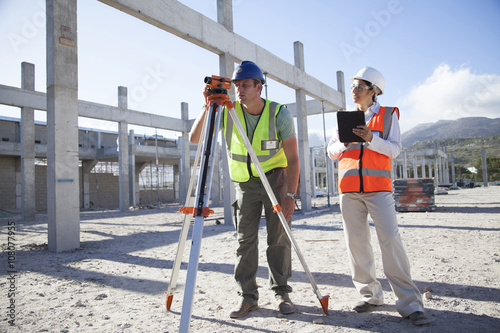 Surveyor and architect working at construction site photo