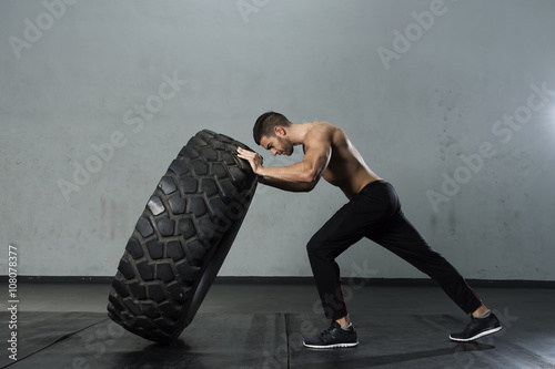 Quadro su tela Bodybuilder flipping tire at the gym