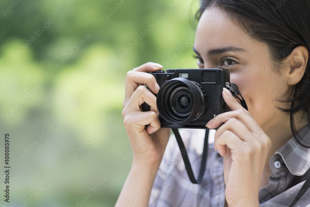 Hispanic woman photographing outdoors Hispanic woman photographing outdoors