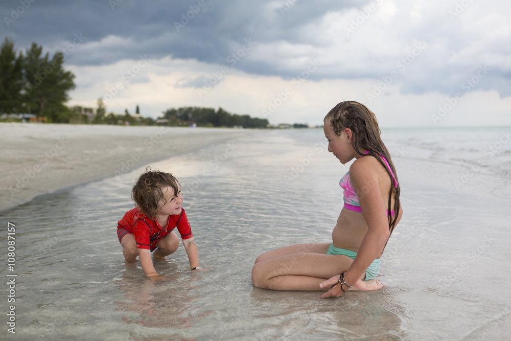 Caucasian brother and sister playing in ocean Caucasian brother and sister playing in ocean