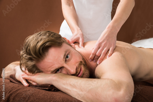 Young Man Receiving Back Massage At Spa