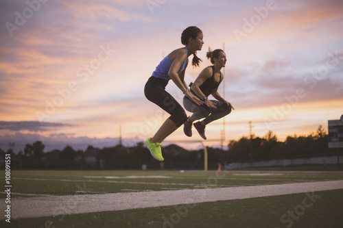 Athletes jumping on sports field photo