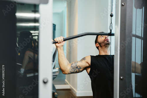 Man using exercise machine in gymnasium photo