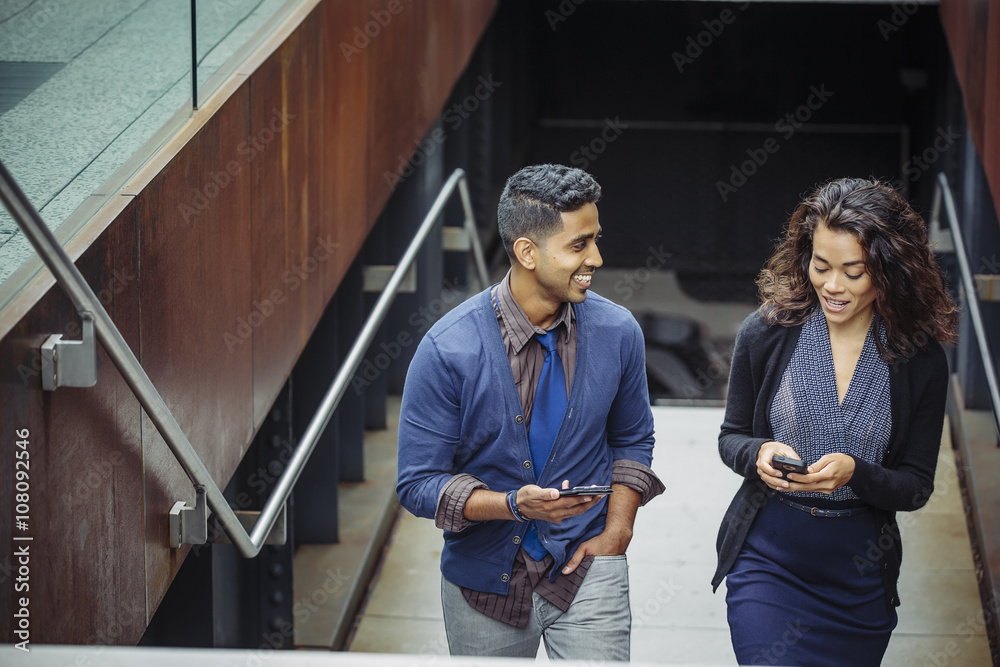 Business people using mobile phones on office steps