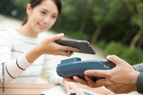 Woman pay with cellphone by NFC technology photo