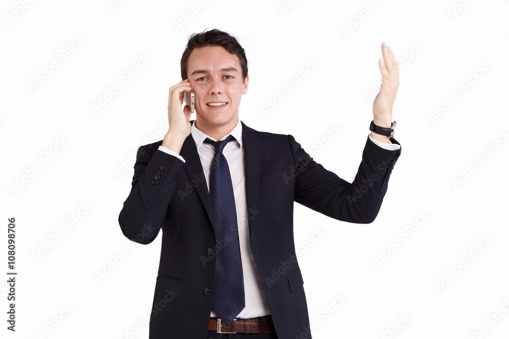 A young caucasian male businessman smiling with raised hand holding a mobile phone looking at camera. A young caucasian male businessman smiling with raised hand holding a mobile phone looking at camera.