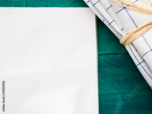 Open note book with blank page on green table