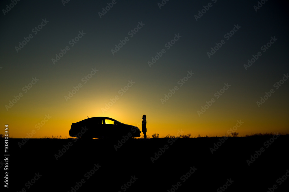Fototapeta premium Silhouette of sedan car on the background of beautiful sunset