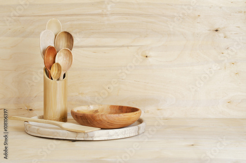 Home Kitchen Decor: wooden cutlery, spoons in a bamboo container on a wooden board background, rustic style.
