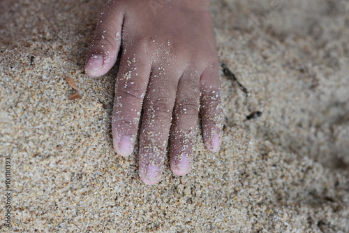 kids hand on sand