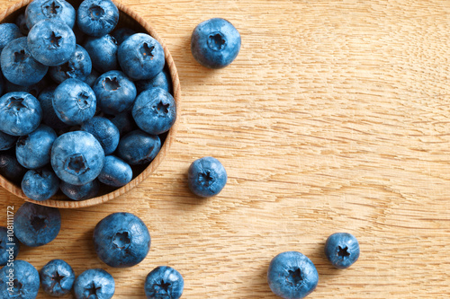 Healthy blueberries in bowl on wooden background. Close up, top view, high resolution product. Harvest Concept
