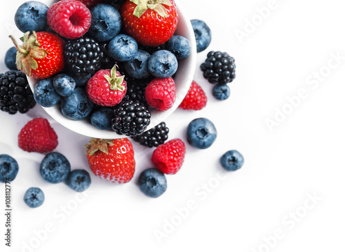 Ceramic bowl with blueberries  strawberries and blackberries on white background. Close up  high resolution product. Harvest Concept