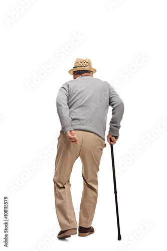 Aged man walking with a black cane