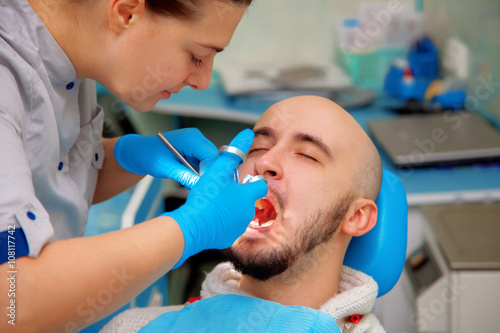 Professional dentist treats teeth patient