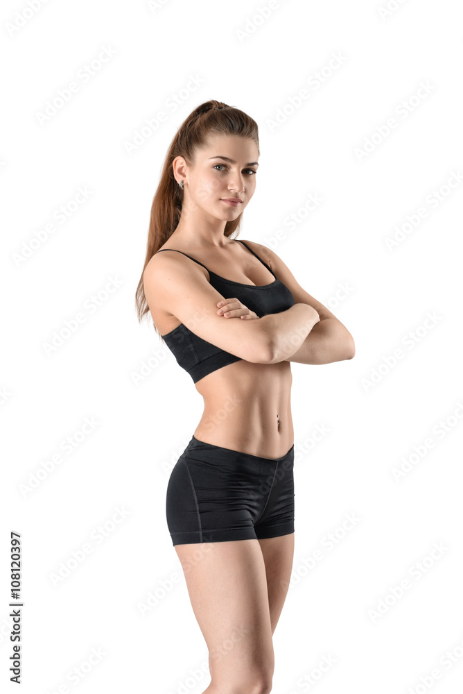 Cutout fitness woman in shorts and a tank top standing sideways with her arms folded Cutout fitness woman in shorts and a tank top standing sideways with her arms folded