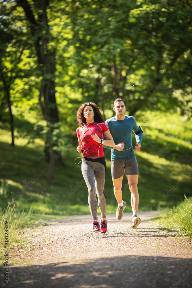 Amidst nature's beauty, a young couple enjoys a refreshing jogging, savoring the fresh air and beautiful spring surroundings. Amidst nature's beauty, a young couple enjoys a refreshing jogging, savoring the fresh air and beautiful spring surroundings.