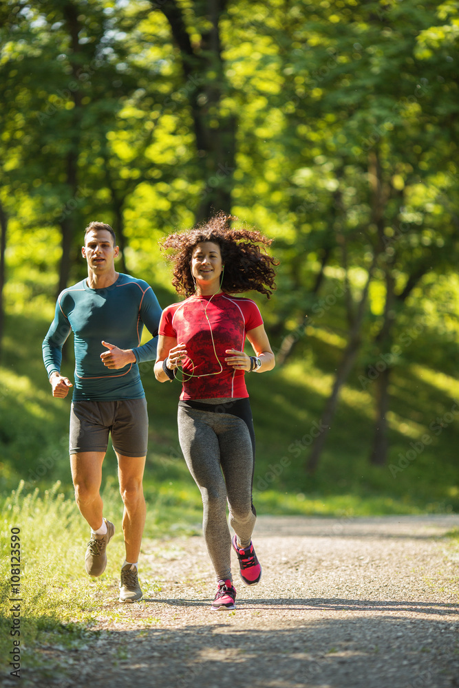 Amidst nature's beauty, a young couple enjoys a refreshing jogging, savoring the fresh air and beautiful spring surroundings. Amidst nature's beauty, a young couple enjoys a refreshing jogging, savoring the fresh air and beautiful spring surroundings.