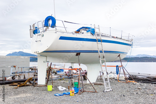A white boat being repaired and restored in the port