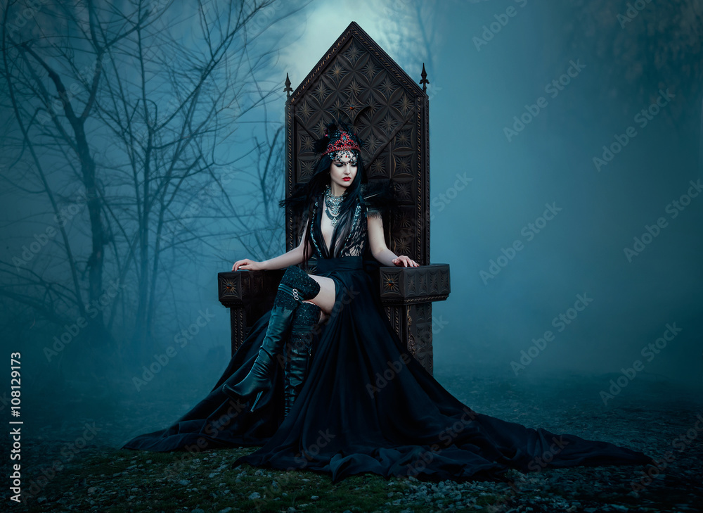dark evil queen sitting on a luxurious throne,dark boho, cosplay to the  film SNOW WHITE AND THE HUNTSMAN ,wild Princess , vampire , hip toning ,  creative color.dark boho Stock Photo