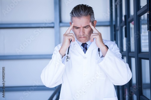 Thoughtful doctor standing in hospital