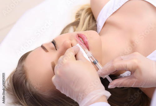 Beautiful woman gets an injection in her lips.