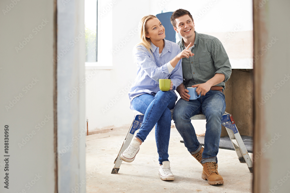 Couple Sitting In Property Being Rennovated Couple Sitting In Property Being Rennovated