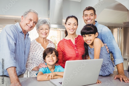 Portrait of happy family with laptop at home