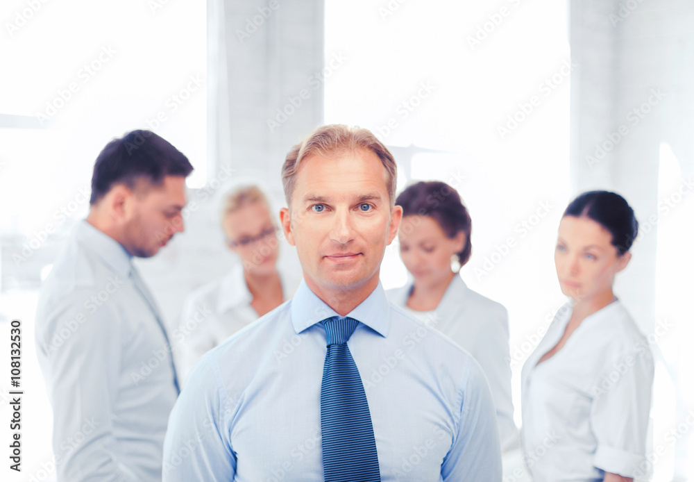 businessman in office with group on the back businessman in office with group on the back