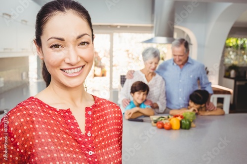 Happy woman with family preparing food in background