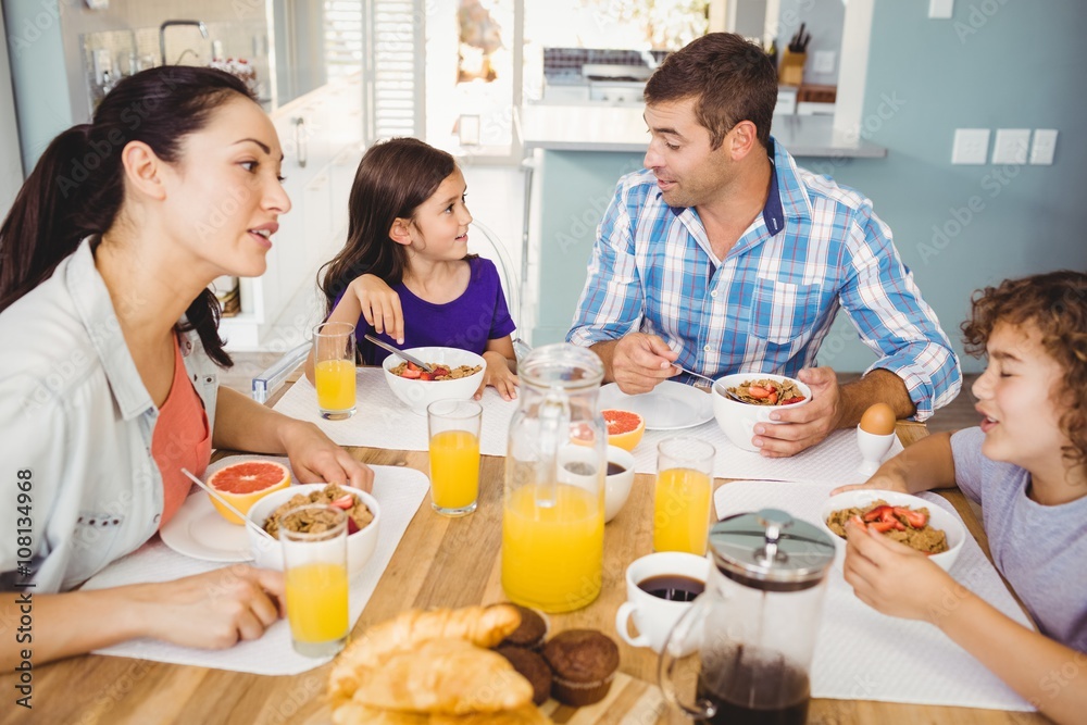 Happy family talking while having breakfast