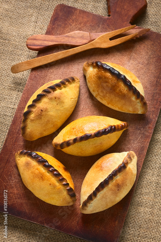 Traditional Bolivian savory pastries called Saltena filled with thick meat stew, photographed with natural light (Selective Focus, Focus on the top of the saltenas) photo