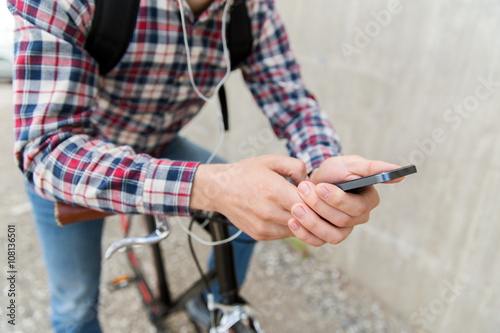 hipster man in earphones with smartphone and bike © Syda Productions
