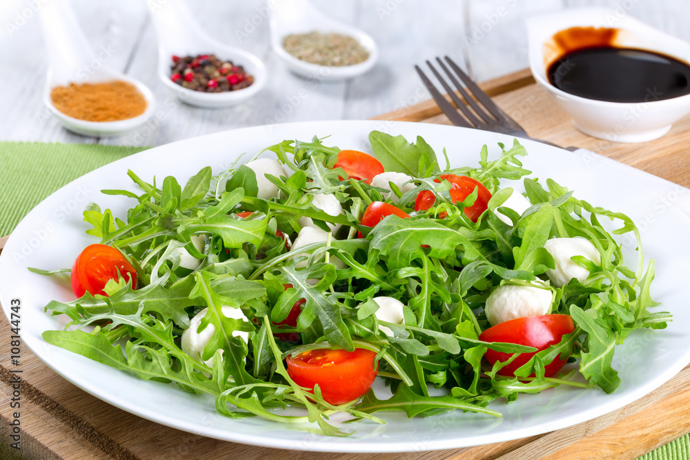 salad with tomatoes, mini mozzarella, arugula, close-up