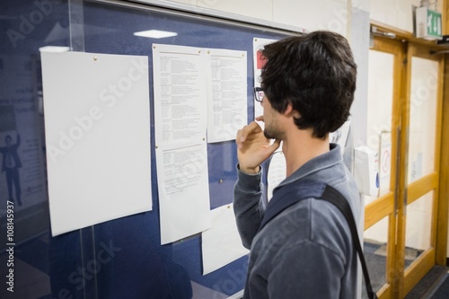 Student reading notice board 