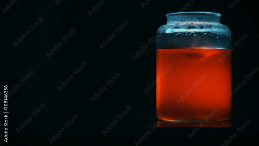 Orange Mysterious Liquid Whirl in a Glass Jar with Back Light Orange Mysterious Liquid Whirl in a Glass Jar with Back Light