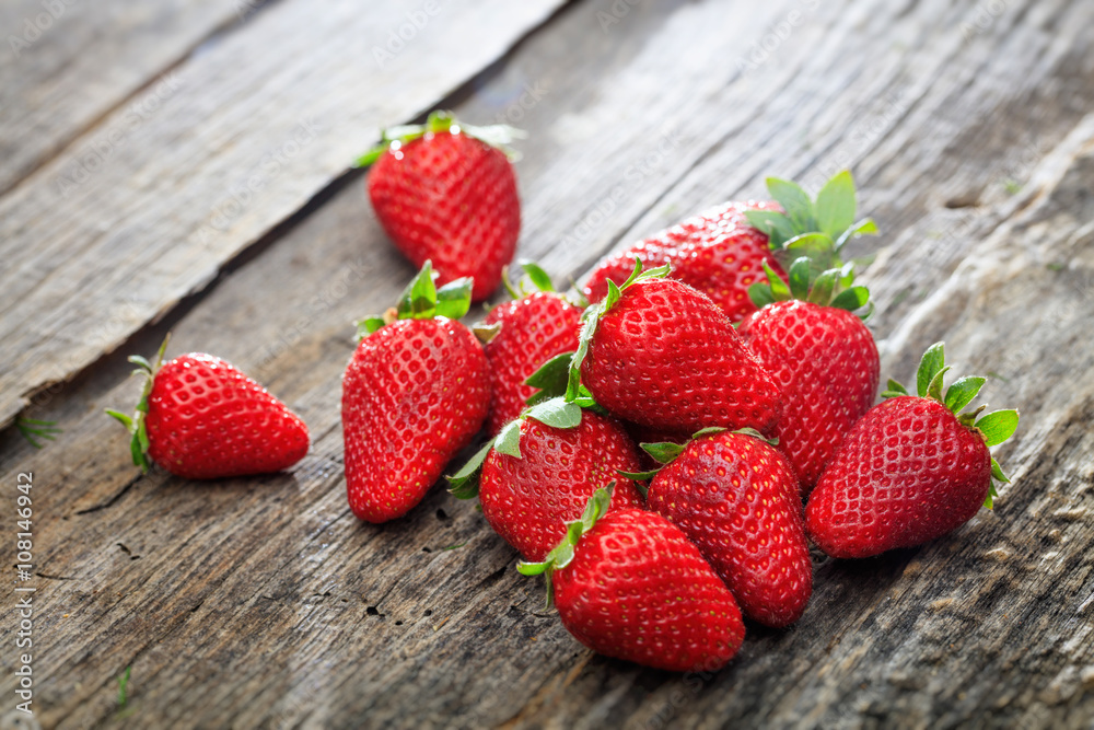 Bunch of red strawberries set on old wooden surface