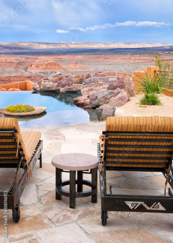 Infinity pool and lounge chairs with a view of endless desert © Crin