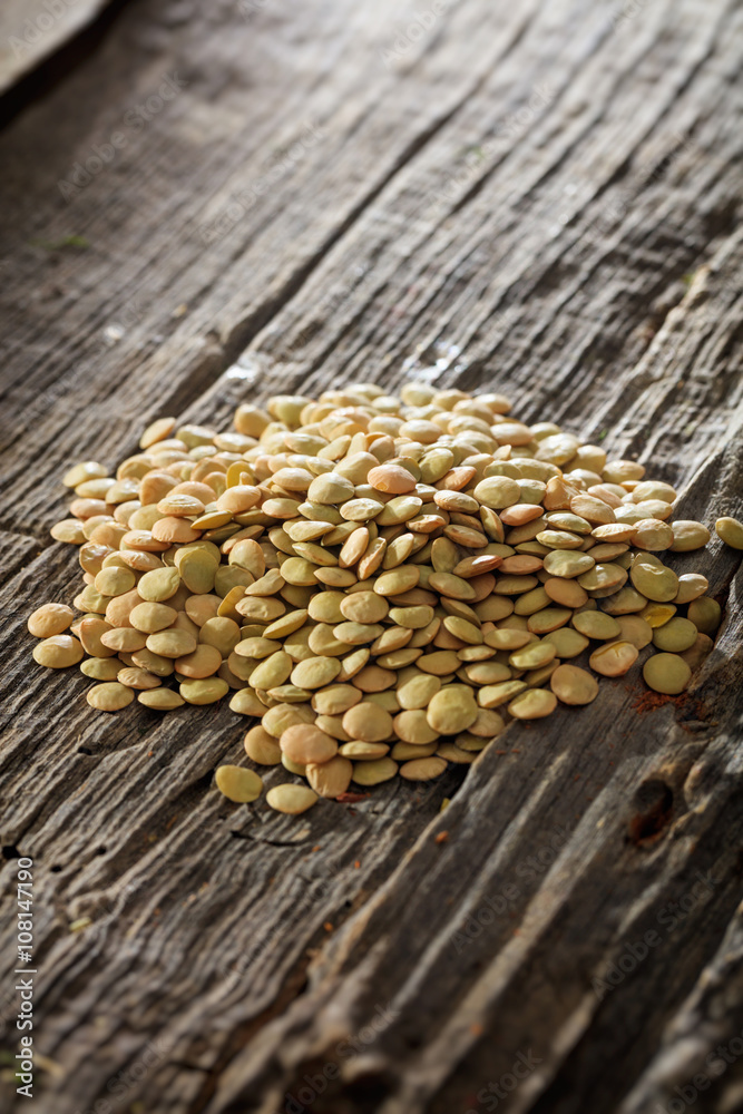 Obraz premium Brown lentils set on old wooden surface