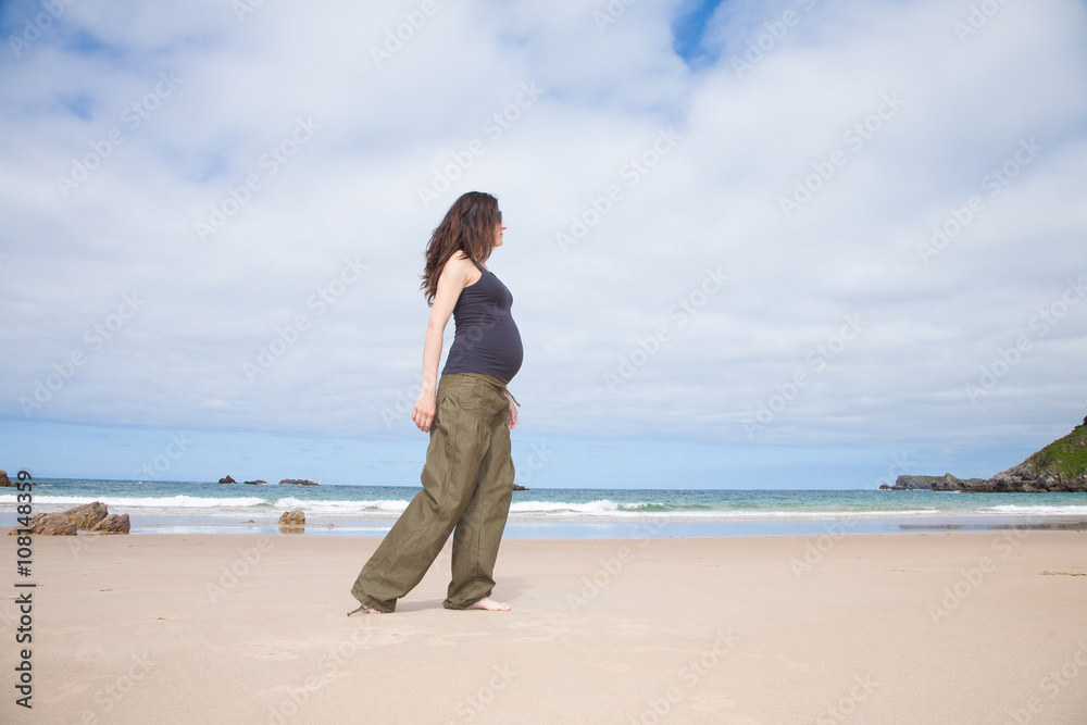 grey shirt pregnant walking next to ocean grey shirt pregnant walking next to ocean