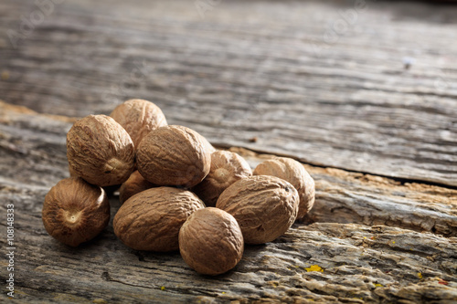 Photography Dried nutmeg seeds set on old wooden surface