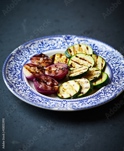 Grilled zucchini and red onion with sea salt on a plate