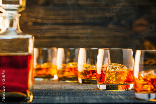 selective focus glass of cold whiskey on wooden-table