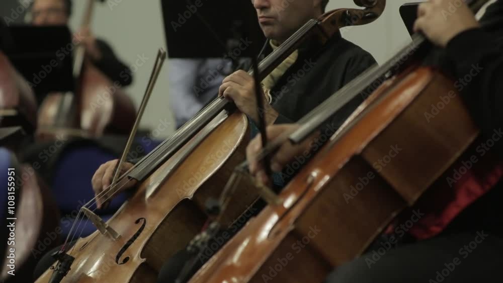 Professional male cellist playing his cello, classical music solo performance Professional male cellist playing his cello, classical music solo performance