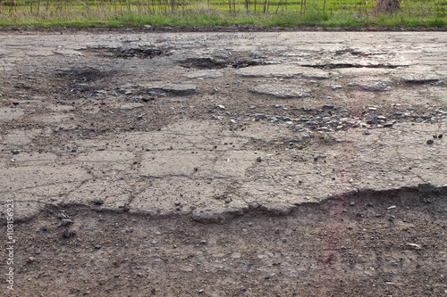 pits and potholes on asphalt road. The bad broken road