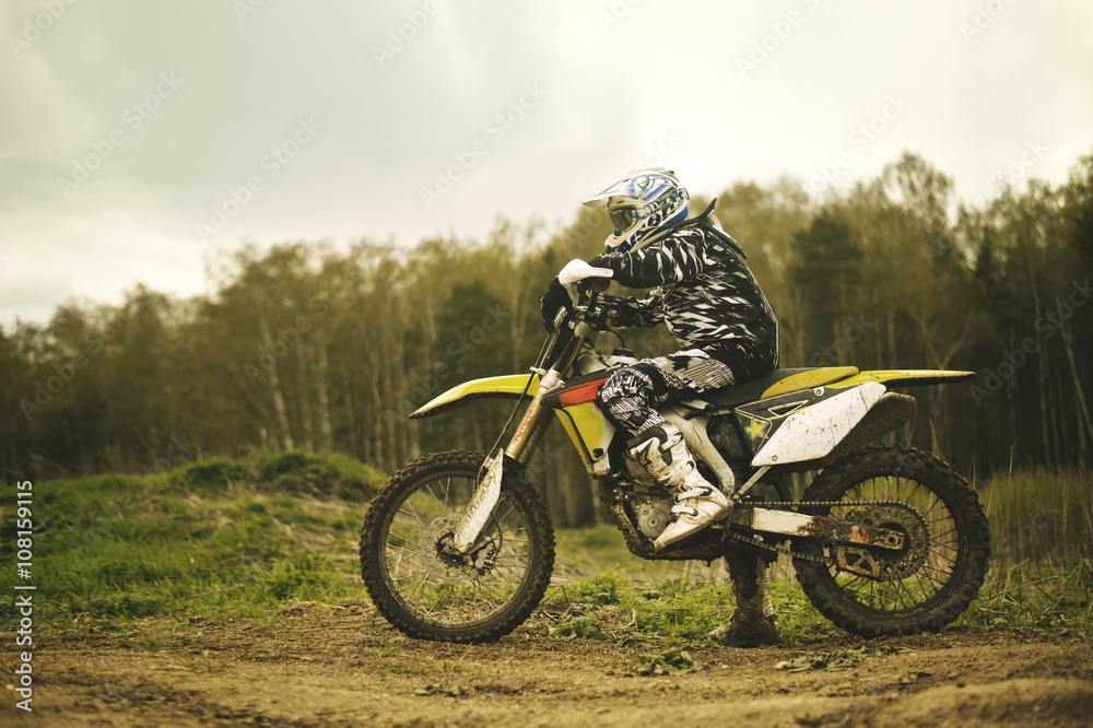 Caucasian man riding dirt bike in field Caucasian man riding dirt bike in field