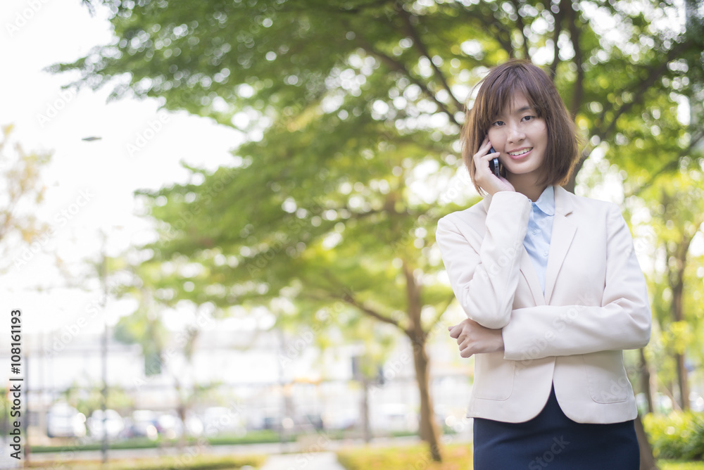 Attractive asian business woman using on smartphone outside Offi Attractive asian business woman using on smartphone outside Offi