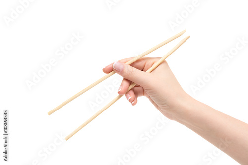 Female hand holds chopsticks on a white background.