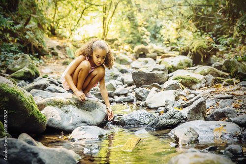 Mixed race girl exploring stream